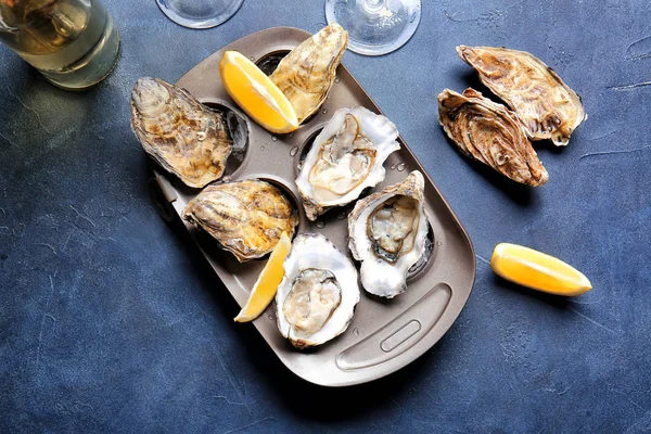 Plate with tasty oysters on color background — Stockfoto
