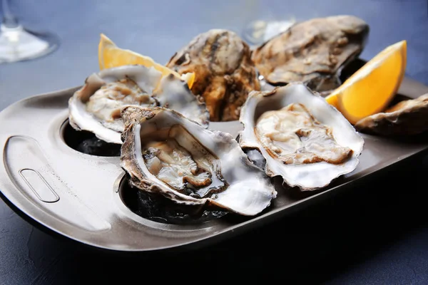 Plate with tasty oysters on color background — Stockfoto