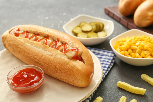 Plate with tasty hot dog on table — Stock Photo, Image