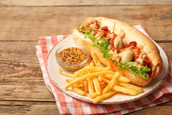 Tasty hot dog with french fries on wooden background — Stock Photo, Image