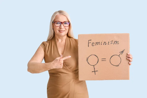 Dame met karton met symbolen van man en vrouw op kleur achtergrond. Begrip feminisme — Stockfoto