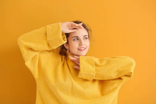 Gyönyörű fiatal nő meleg pulóver a színes háttér — Stock Fotó