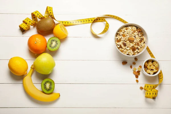 Different healthy food with measuring tape on white wooden background. Diet concept — Stok fotoğraf