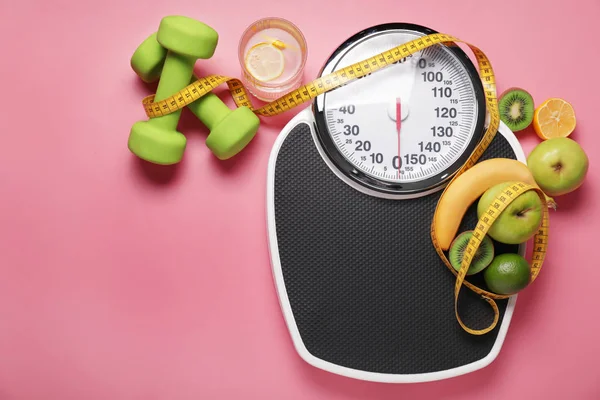 Different healthy food with measuring tape, scales and dumbbells on color background. Diet concept — Stok fotoğraf