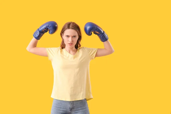Young woman in boxing gloves on color background. Concept of feminism — Stock Photo, Image