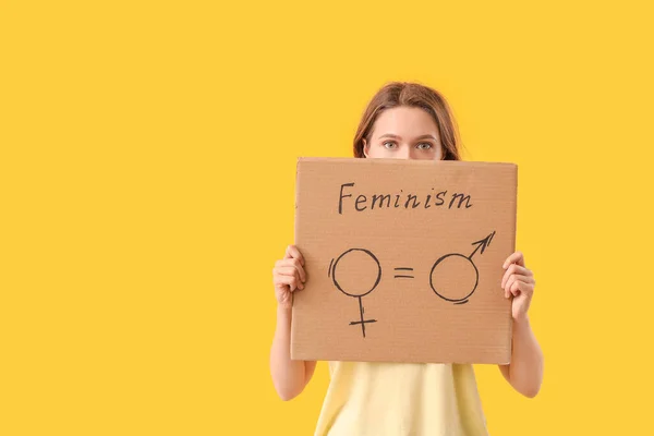 Young lady holding cardboard with symbols of man and woman on color background. Concept of feminism — 스톡 사진