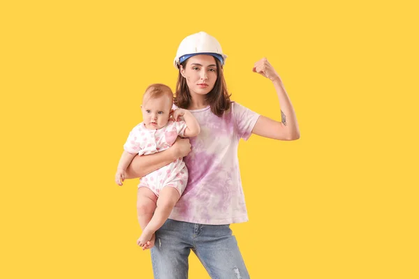 Young woman with baby on color background. Concept of feminism — Stockfoto