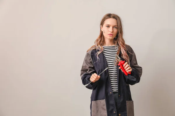 Female worker on light background. Concept of feminism — Stock Photo, Image