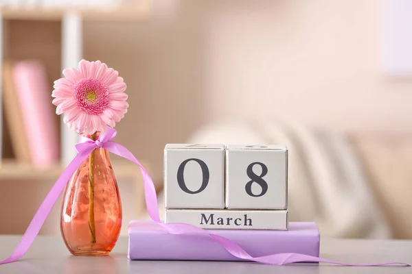 Calendario con data della Giornata Internazionale della Donna, fiore e libro sul tavolo in camera — Foto Stock
