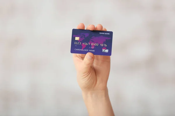 Female hand with credit card on light background — Stock Photo, Image