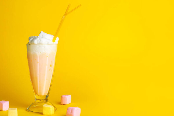 Glass of tasty milkshake on color background