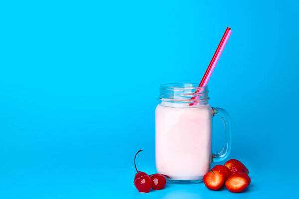 Масонская банка вкусного молочного коктейля на цветном фоне
