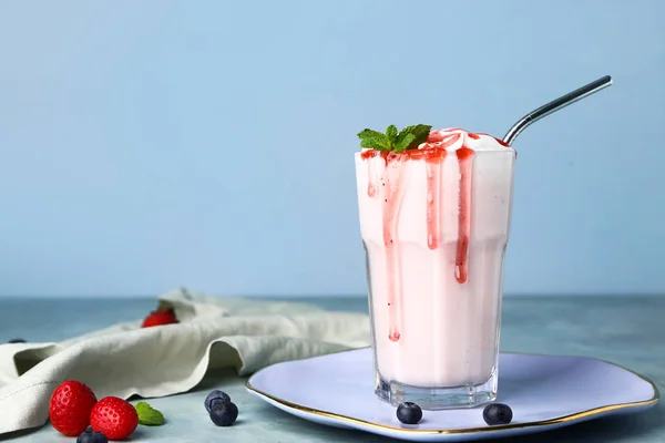 Glass of tasty milkshake on color background — Stockfoto