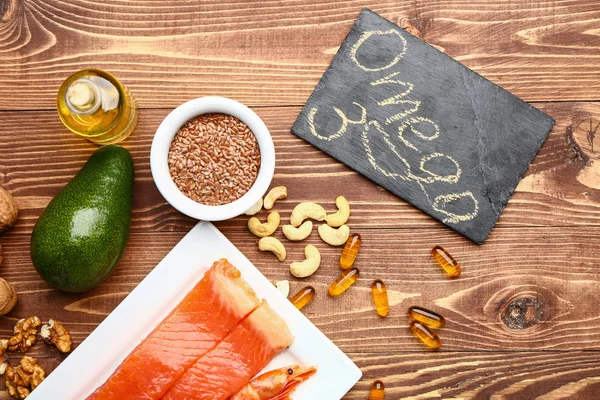 Set of healthy products with high omega 3 and fish oil pills on wooden table — Stock Photo, Image