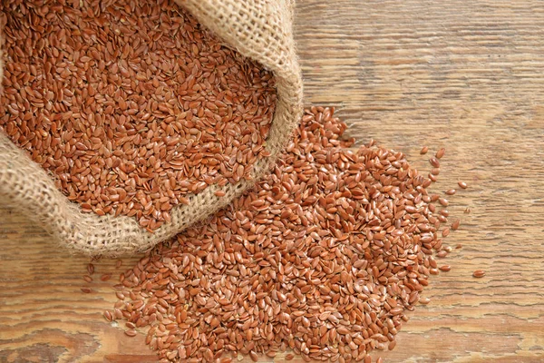 Bag with flax seeds on wooden background — Stock Photo, Image