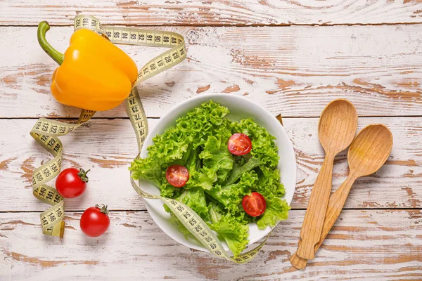 Different healthy food with measuring tape on wooden background. Diet concept — Stock Image Different healthy food with measuring tape on wooden background. Diet concept Royalty Free Stock Photos
