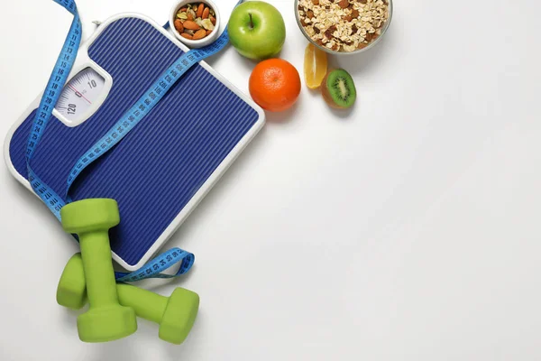 Different healthy food with measuring tape, dumbbells and scales on light background. Diet concept — Stock Image Different healthy food with measuring tape, dumbbells and scales on light background. Diet concept Royalty Free Stock Photos