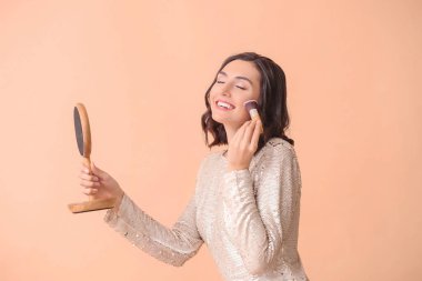 Renkli arka plana makyaj yapan güzel genç bir kadın.