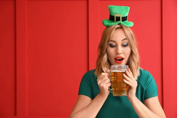 Belle jeune femme avec de la bière sur fond de couleur. Célébration de la Saint Patrick — Photo