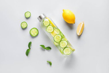 Hafif arkaplanda bir şişe soğuk salatalık suyu.
