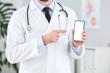 Klinikte cep telefonu olan bir erkek doktor.