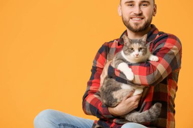 Renkli arka planda sevimli kedisi olan adam