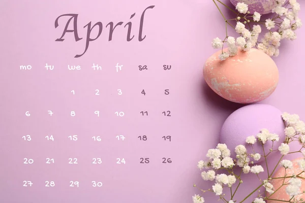 Пасхальные яйца с цветами и календарь на цветном фоне — стоковое фото