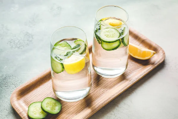 Glasses of cold cucumber water on color background — Stock Photo, Image