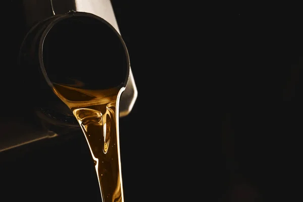 Dose mit einströmendem Autoöl auf dunklem Hintergrund — Stockfoto