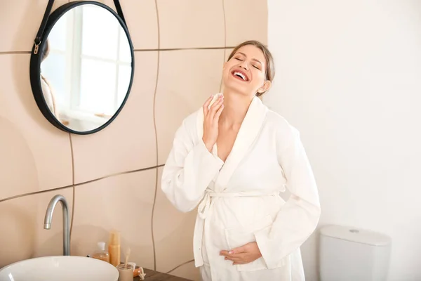 Schöne schwangere Frau Creme im Badezimmer — Stockfoto