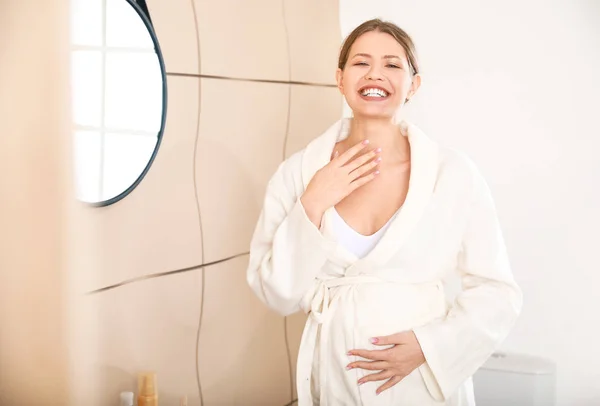 Hermosa mujer embarazada aplicando crema en el baño — Foto de Stock