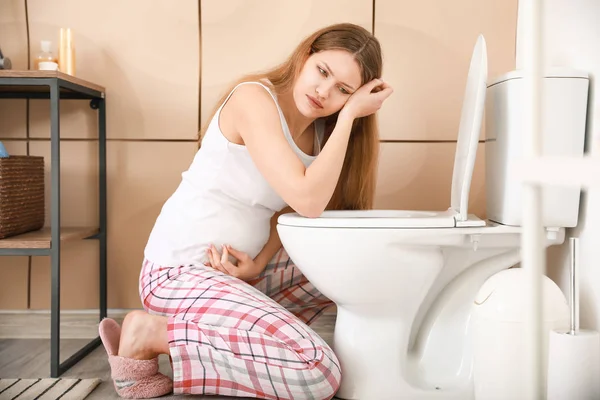 Zwangere vrouw die lijdt aan toxicose in de badkamer — Stockfoto