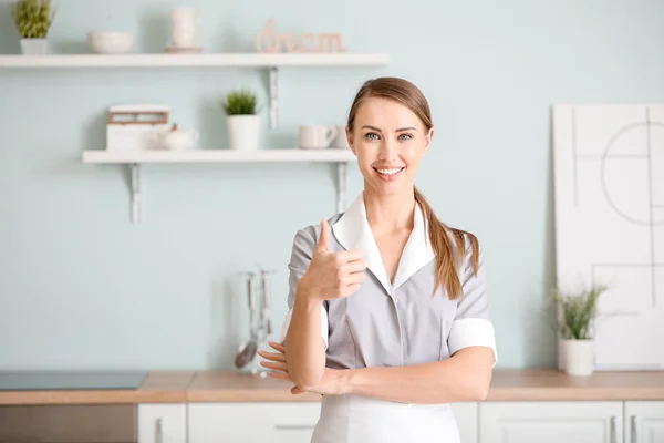 Retrato de hermosa camarera mostrando el pulgar hacia arriba en la cocina —  Fotos de Stock