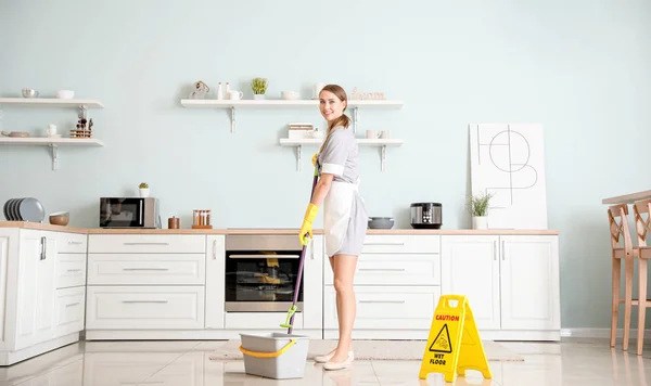 Gyönyörű fiatal szobalány takarítás konyha — Stock Fotó