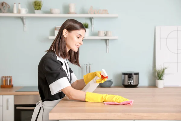 Güzel genç oda hizmetçisi mutfağı temizliyor. — Stok fotoğraf
