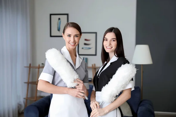 Portrait of beautiful young chambermaids in hotel room — Stock Photo, Image