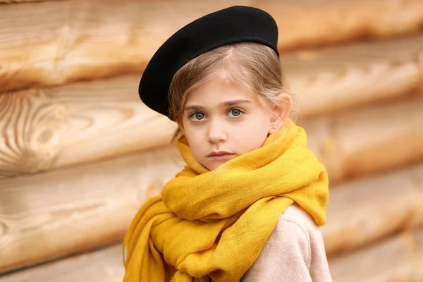 Linda niña en otoño cerca de la pared de madera al aire libre — Foto de Stock