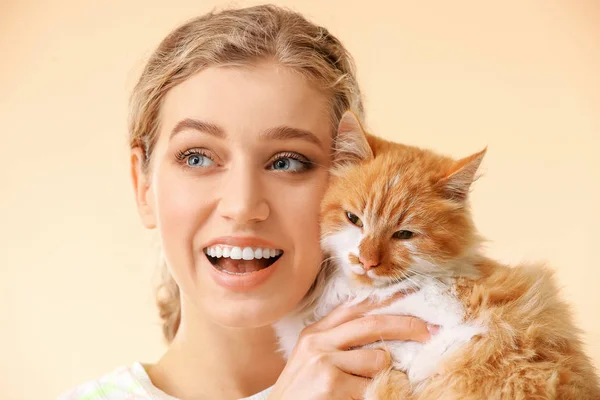 Beautiful young woman with cute cat on color background — Stock Photo, Image