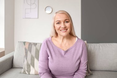 Evde görüntülü konuşma yapan olgun bir kadın