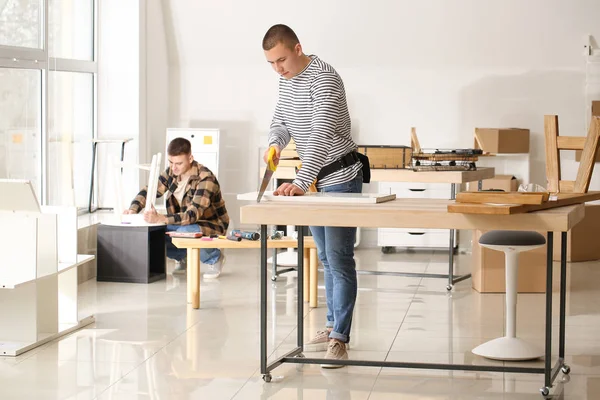 Handymen assembling furniture in workshop — Stock Photo, Image