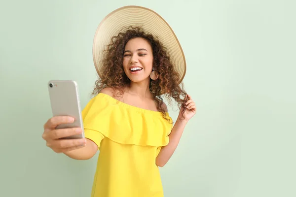 Vacker ung kvinna tar selfie på färg bakgrund — Stockfoto