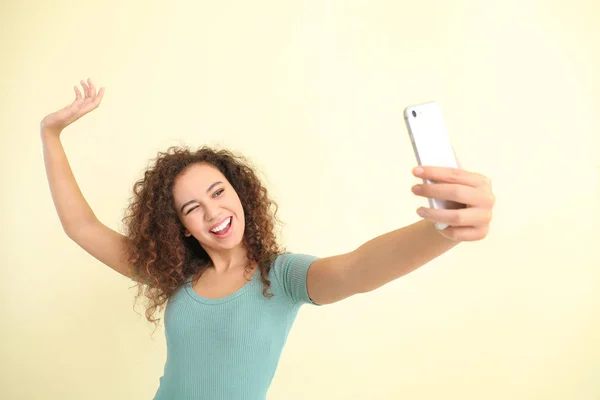 Beautiful young woman taking selfie on light background — 스톡 사진