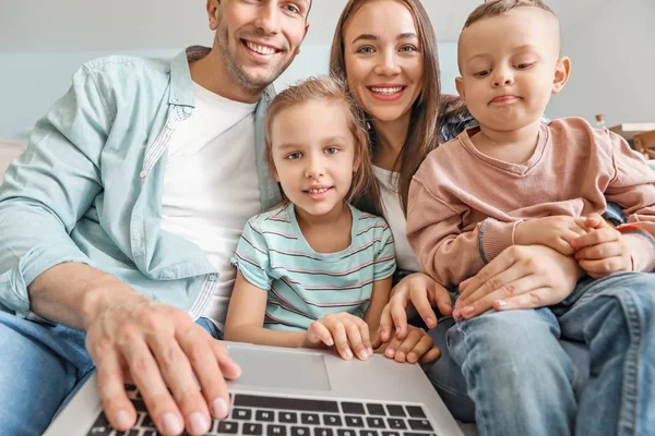 Νεαρή οικογένεια με φορητό υπολογιστή συνομιλίας στο σπίτι — Φωτογραφία Αρχείου