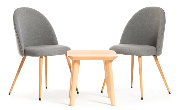 Сучасні стільці та стіл на білому тлі — стокове фото