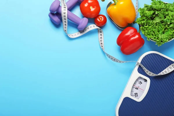 Different healthy food with measuring tape, scales and dumbbells on color background. Diet concept — Stok fotoğraf