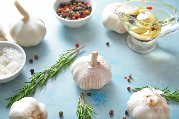 Fresh garlic with spices, oil and herbs on color background — Stock Photo, Image