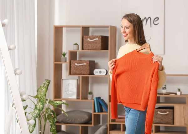 Mooie jonge vrouw met nieuwe kleren in de buurt spiegel thuis — Stockfoto