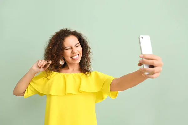 Hermosa mujer joven tomando selfie sobre fondo de color — Foto de Stock