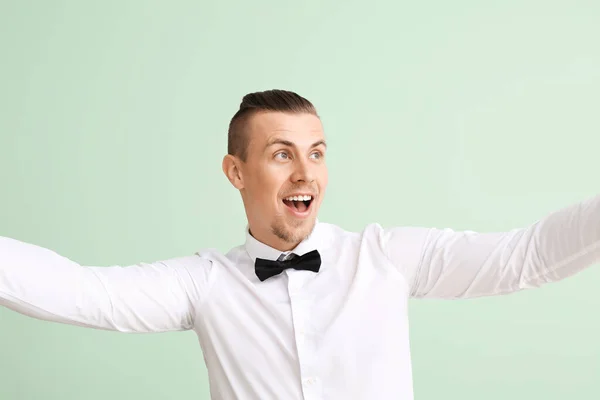 Handsome young man taking selfie on color background — Stock Photo, Image