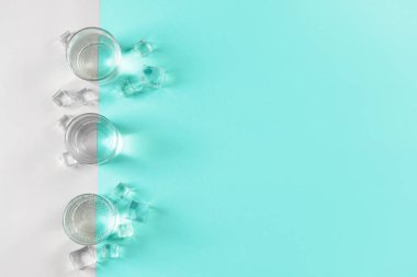 Renkli arka planda temiz su ve buz küpleri